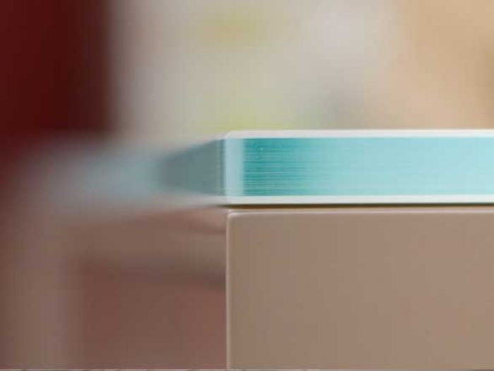 Dettaglio di un mobilletto bagno su misura realizzato dalla nostra falegnameria di Parma in legno laccato lucido con top in vetro.