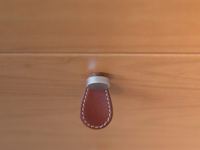 Dettaglio pomello di apertura cassetto realizzato in mrtallo e cuoio.