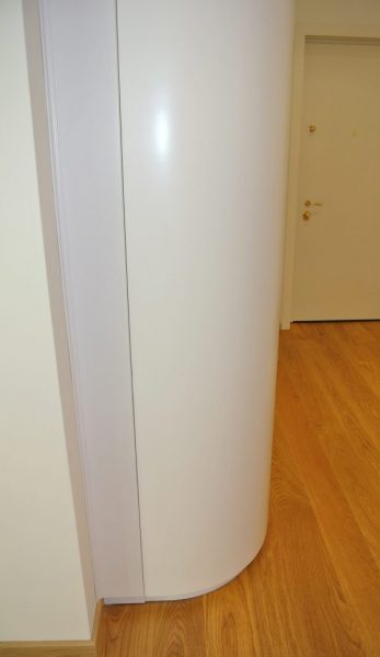 Foto profilo stondato di un armadio su misura per ingresso in legno laccato bianco